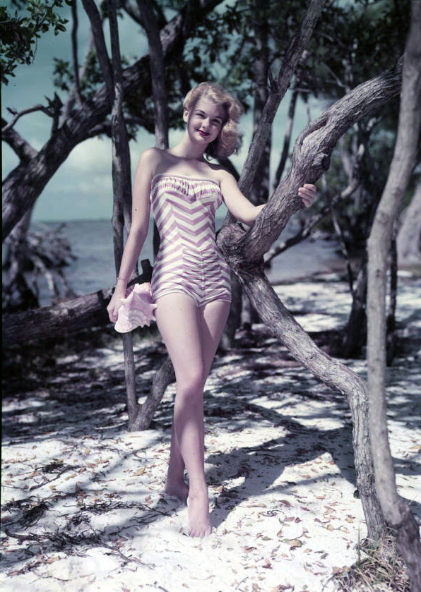 Unidentified young woman modeling by the beach.