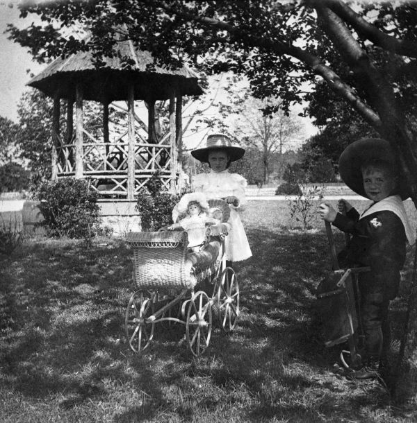 Girl and her doll carriage near gazebo