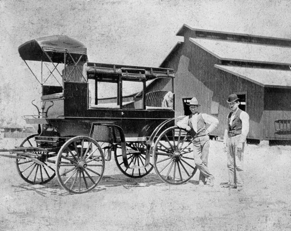 Pair of men posing with carriage