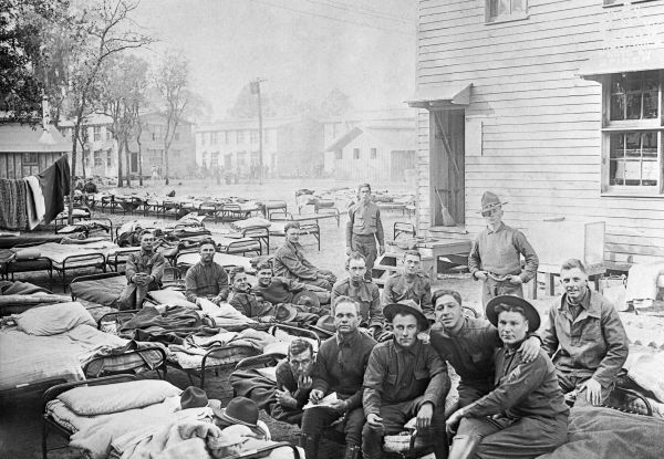 Soldiers relaxing on cots outside barracks - Camp Joseph E. Johnston