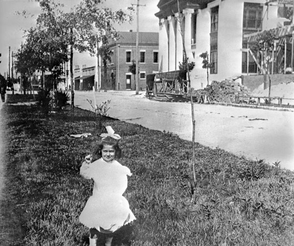 Young girl standing in front of library under construction.