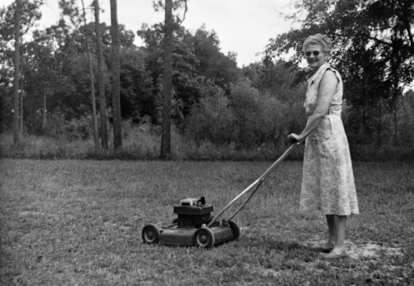 Mrs. Irene Watson, home demonstration club member pushing a lawn mower on "clean-up" day - Lamont, Florida
