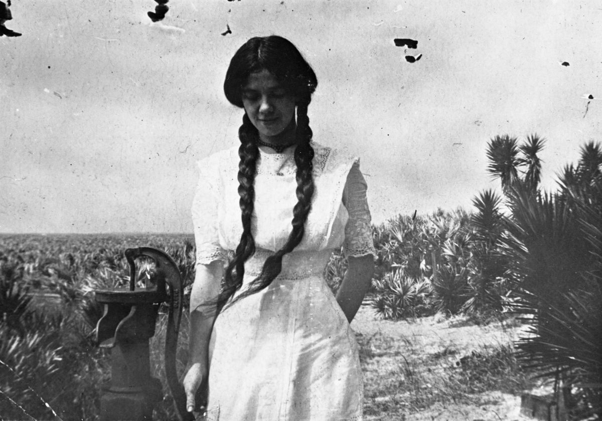 Girl posing at a pitcher pump