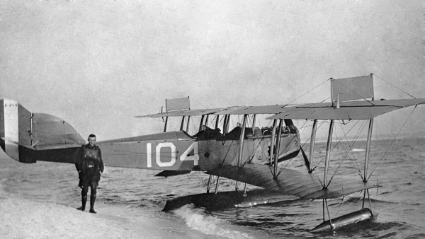 Pilot standing next to airboat at edge of surf - Naval Air Station Pensacola.