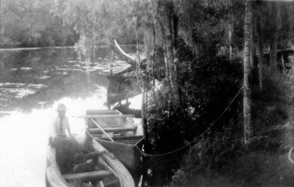 Man sitting in a boat that has been tied at the river's edge