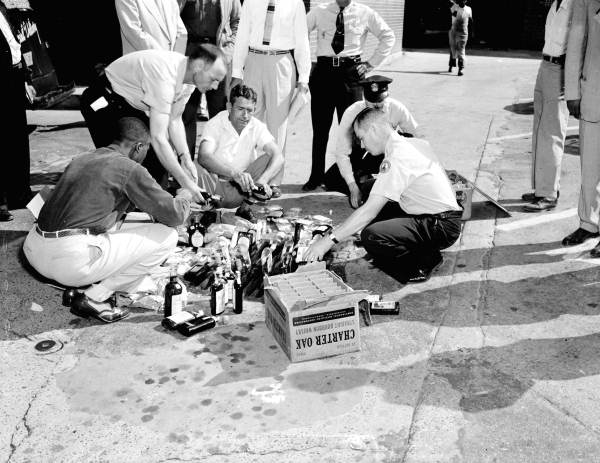 Police destroying confiscated liquor.