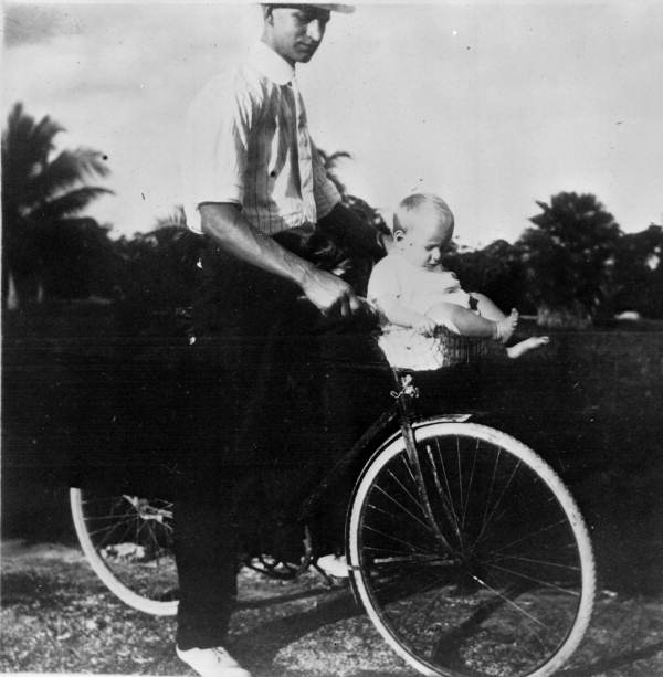 Unidentified man and child on a bicycle