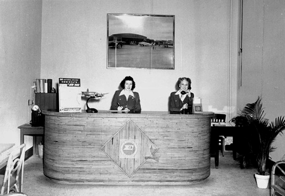Two women employees at desk in Tallahassee office of National Airlines