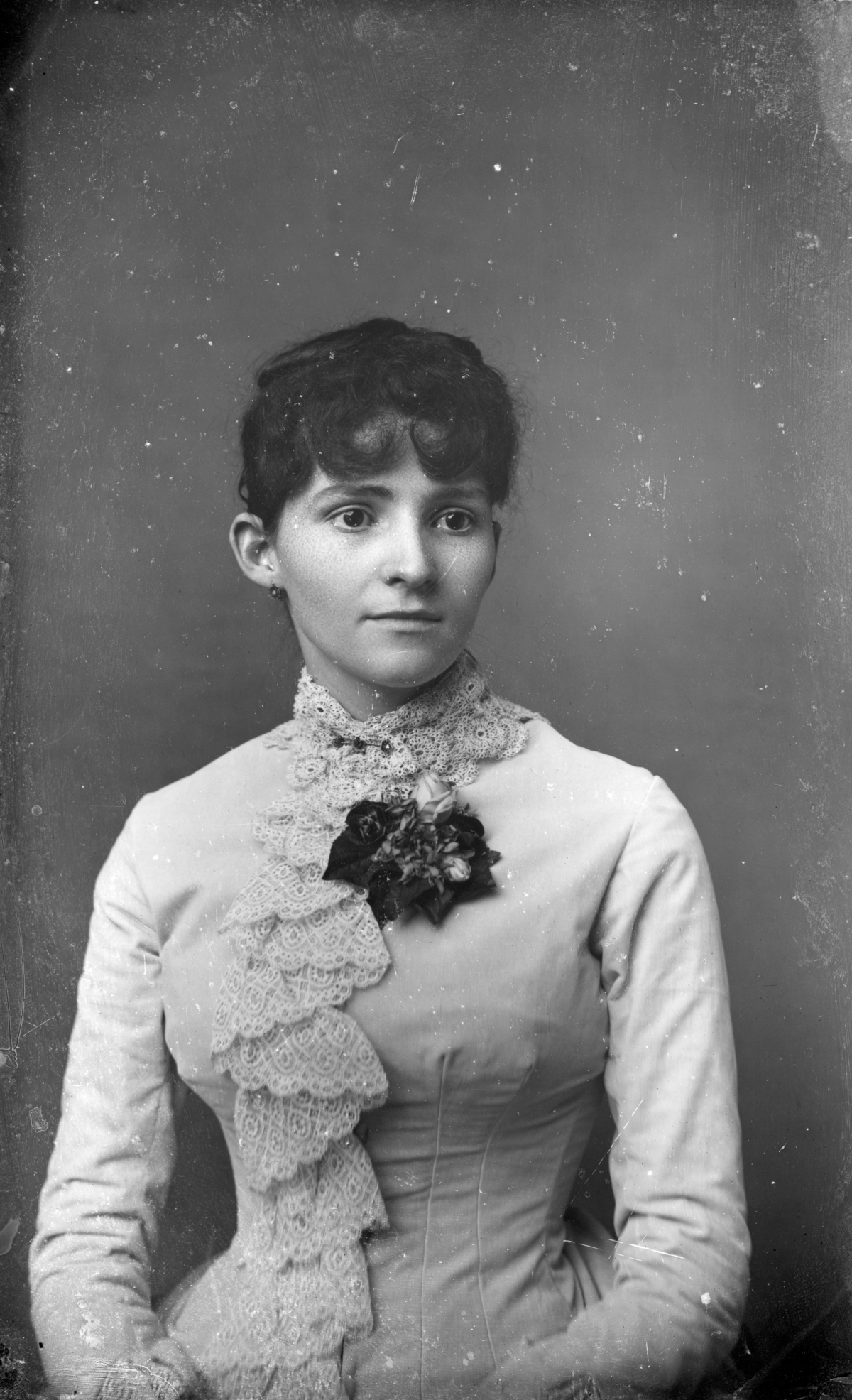 Young woman fashioned in bodice trimmed with lace.