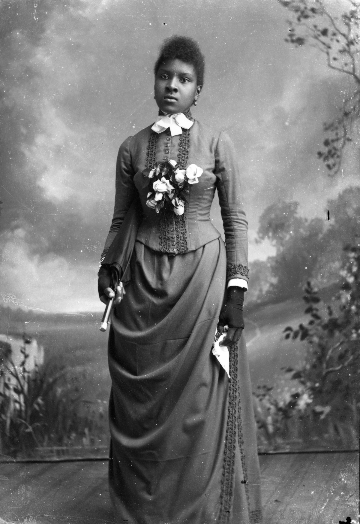 Woman holding a parasol and handkerchief.