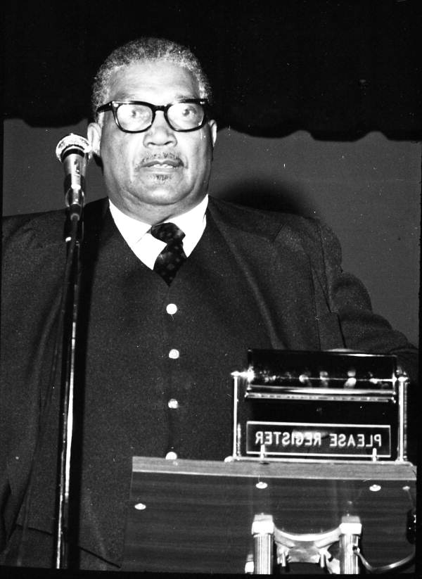 Unidentified African American man delivering a civil rights speech in an auditorium.