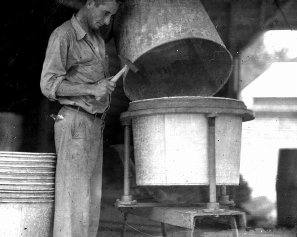 Man assembling galvanized iron barrels