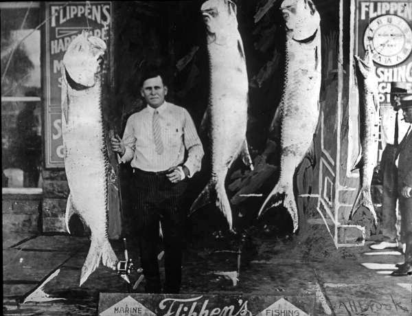 Men standing beside displayed Tarpon and Barracuda