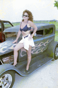 Beauty contestant posing on a hot rod during the Battle of the Bands festival in Okeechobee.