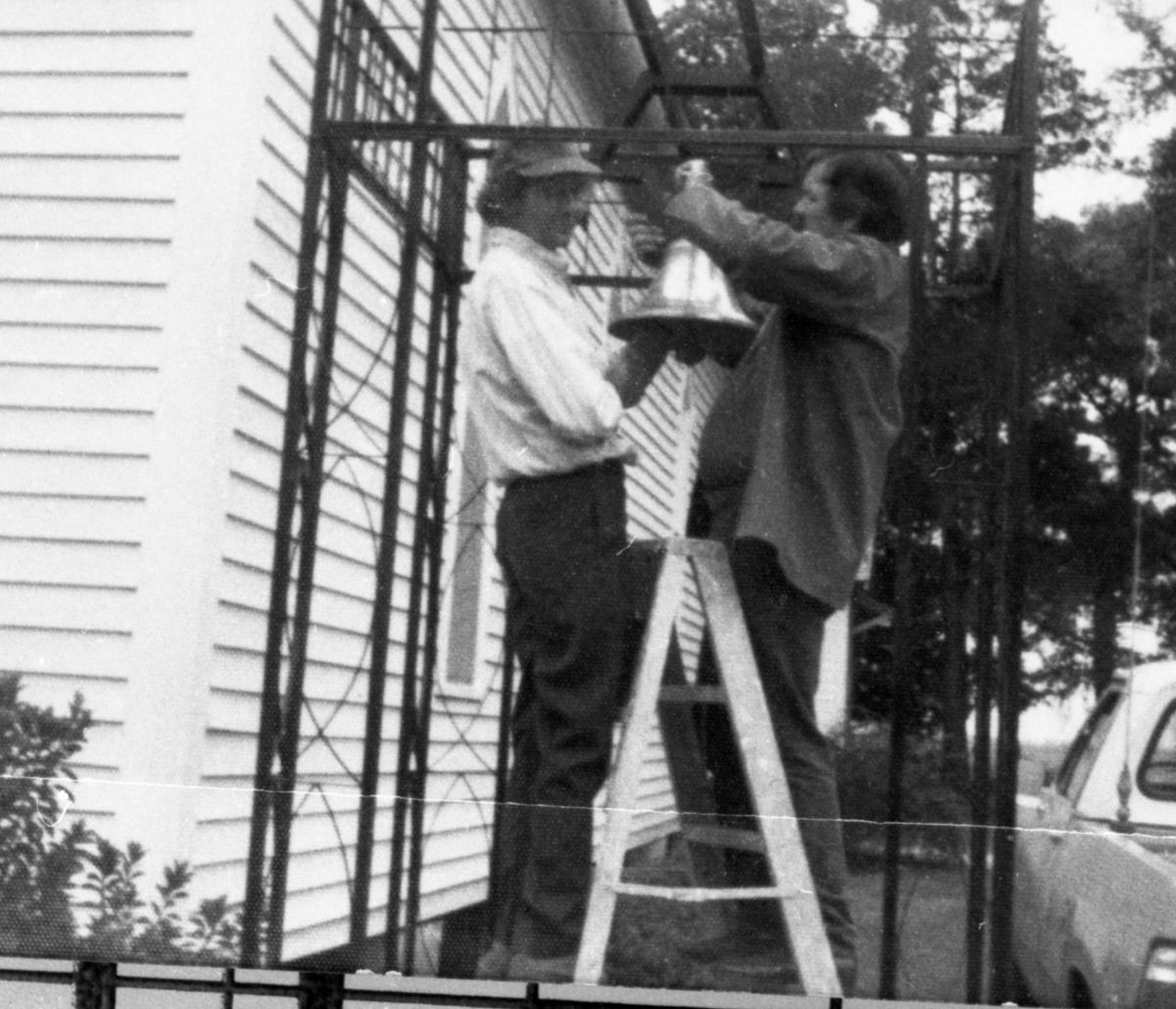 Men installing bell at church - Cherry Lake, Florida