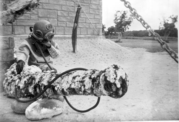 Man in diving suit posing next to cannon at McKee's Museum of Sunken Treasure - Plantation Key, Florida