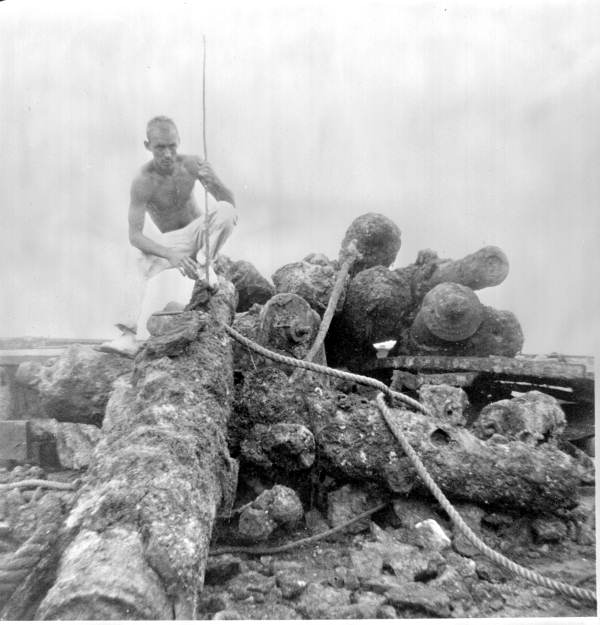 Unidentified man posing on top of cannons retrieved by treasure hunter Art McKee - Plantation Key, Florida