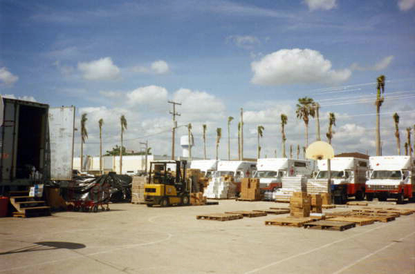 View showing boxes of aid and fleet of American Red Cross trucks in Dade County for victims of Hurricane Andrew.