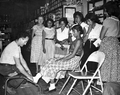 Harry Rubinstein trying shoes on Seminole Indian girls - Dania, Florida