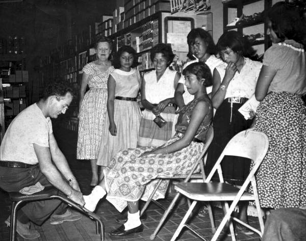 Harry Rubinstein trying shoes on Seminole Indian girls - Dania, Florida