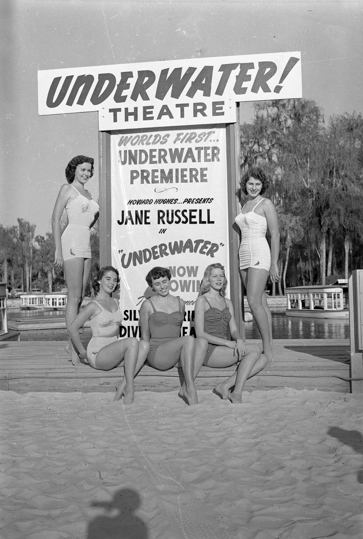 Women in Jantzen suits posing by sign for underwater theater at Silver Springs.