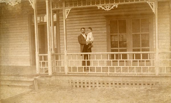 William S. Jennings holding 18-month-old son on porch of his home - Brooksville, Florida.
