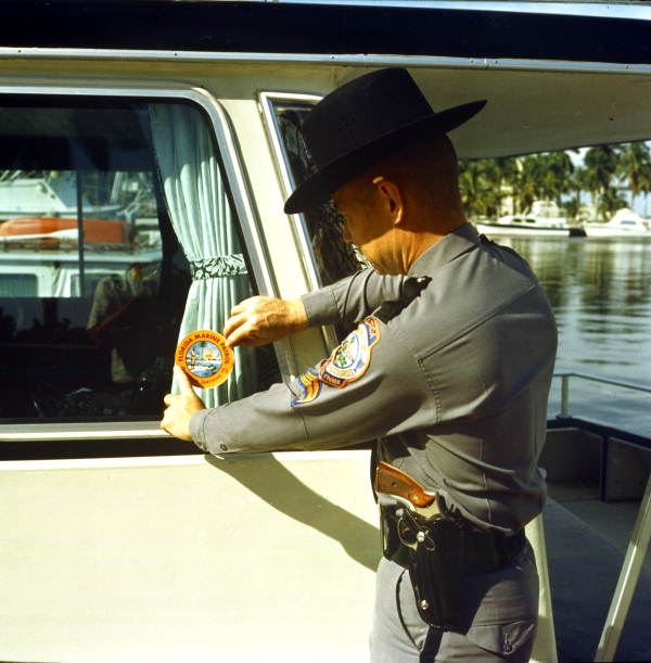 Florida Marine Patrol officer placing decal on his boat