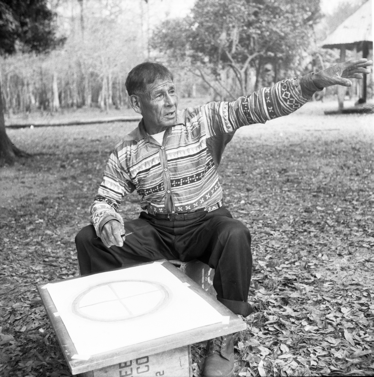 Seminole Indian Medicine Man Josie Billie sitting in chair in front of a Wheel of Life