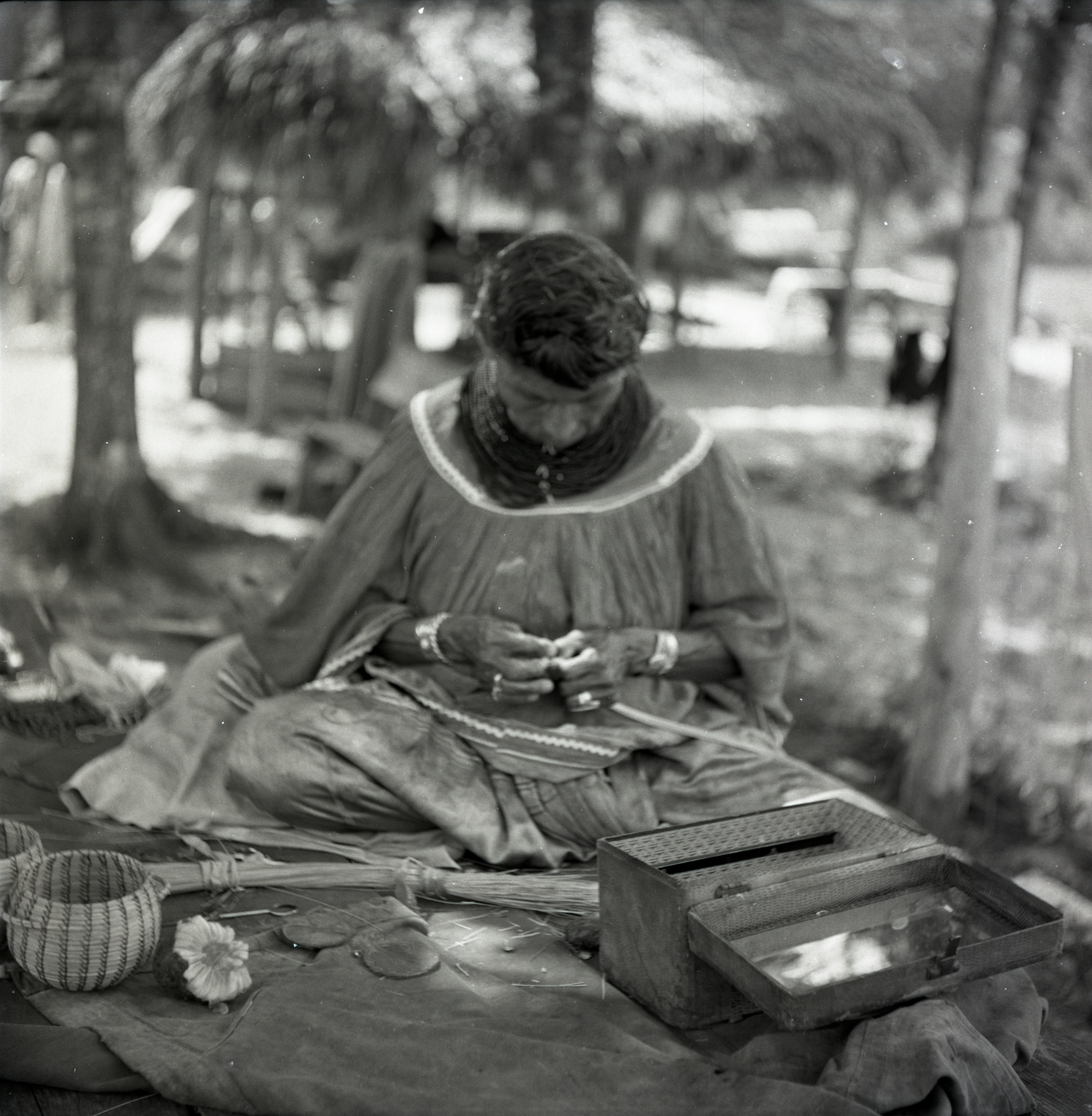Seminole woman weaving baskets