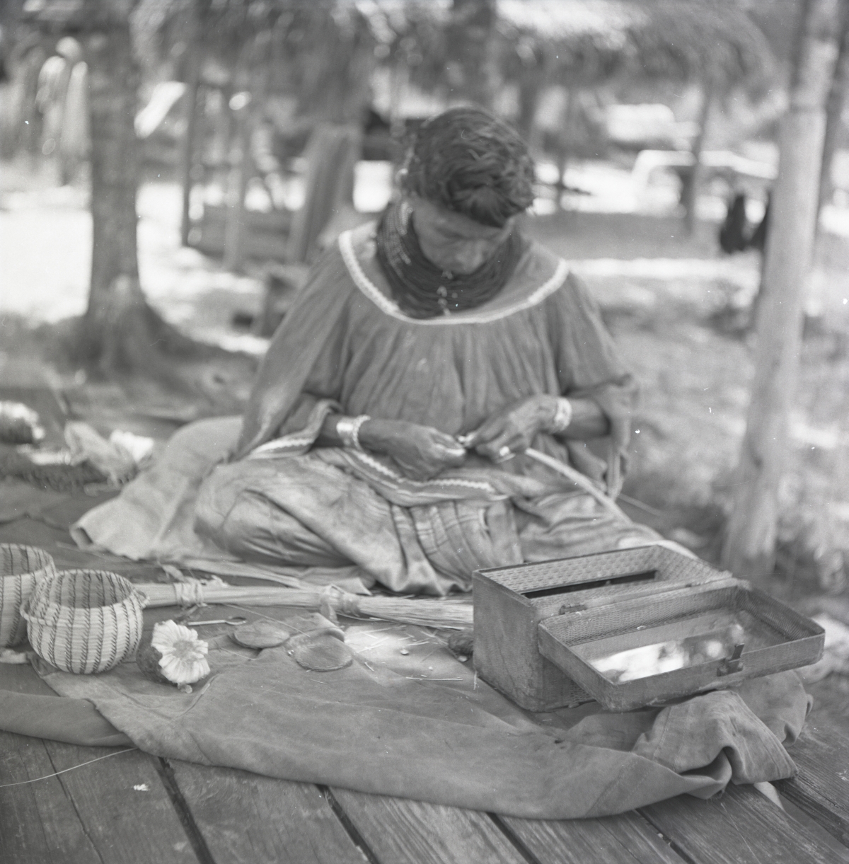 Seminole woman weaving baskets