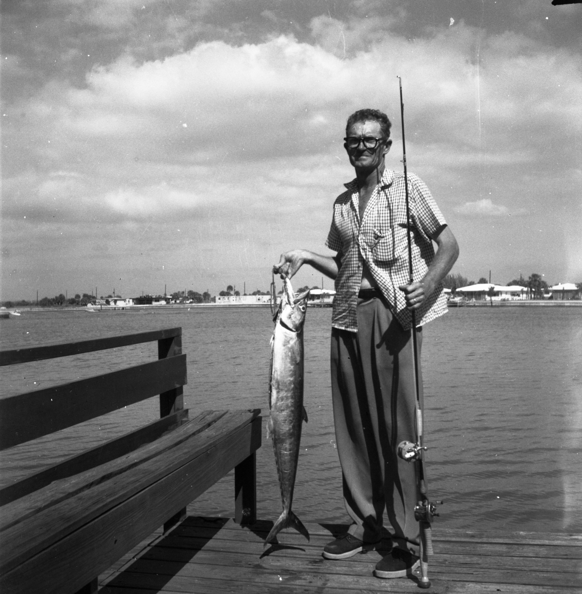 Florida Memory Man standing on dock holding fish and fishing pole Florida Memory Man standing on dock holding fish and fishing pole