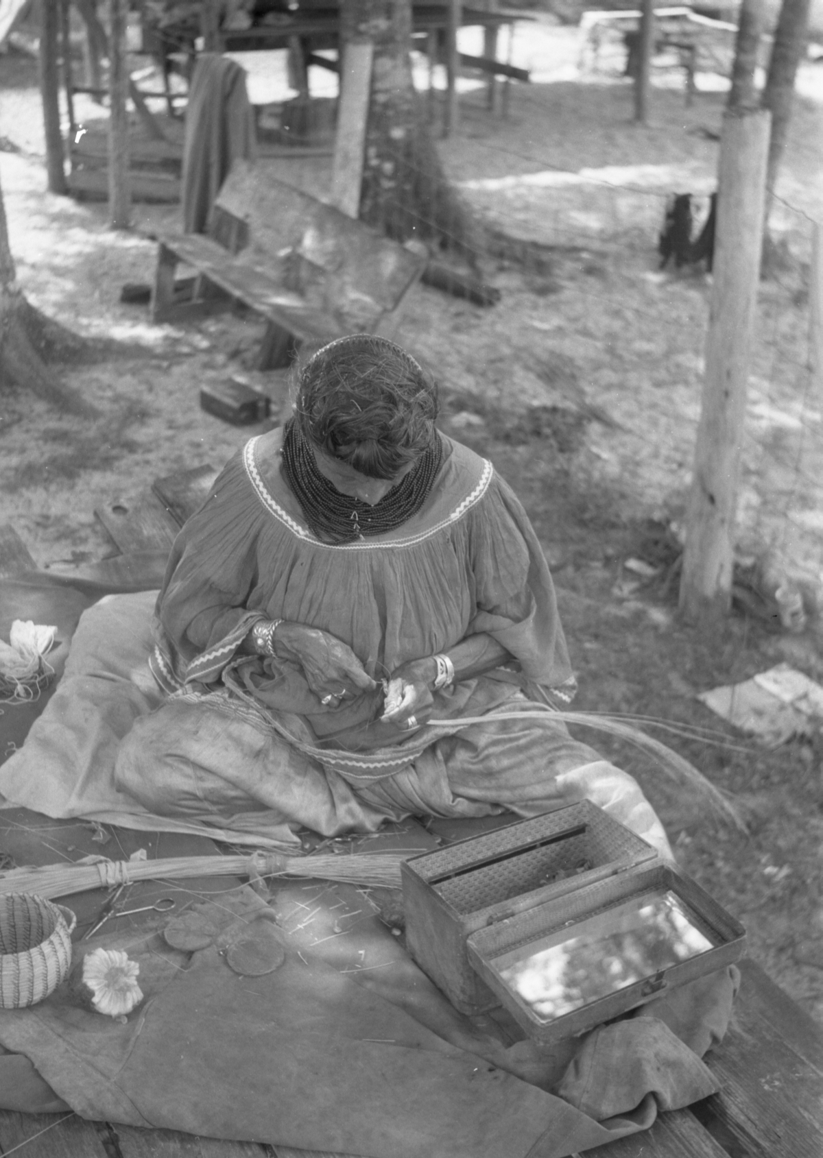Seminole woman weaving baskets