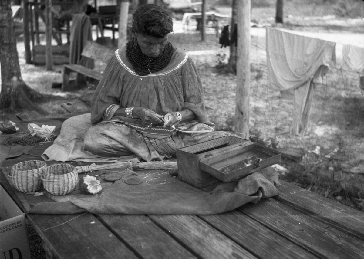 Seminole woman weaving baskets