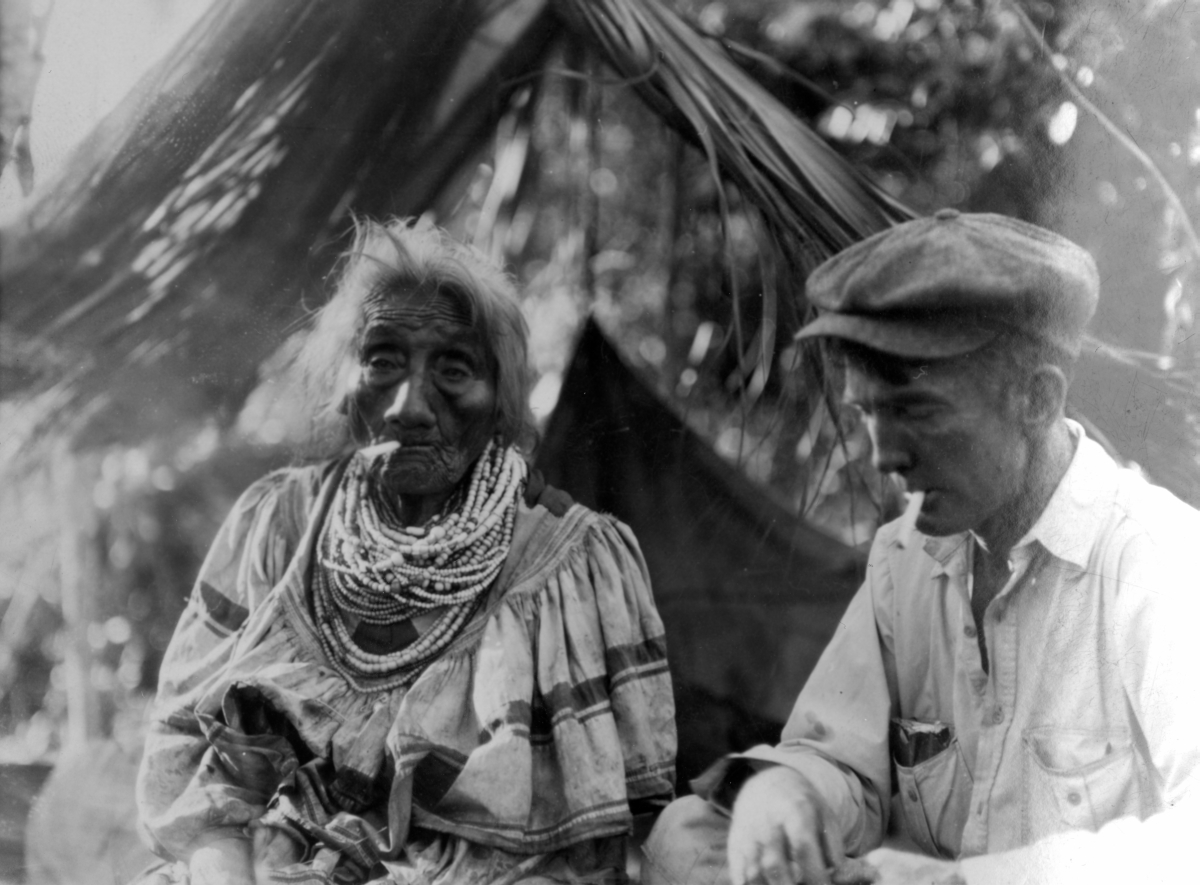 Man smoking with an elderly Seminole woman
