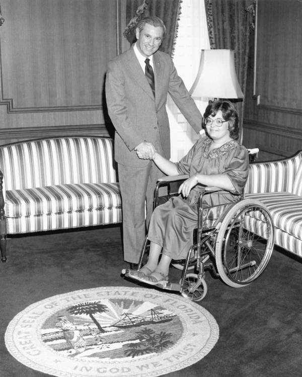 Florida Governor Reubin Askew shaking hands with Miss Wheelchair Florida, Tamara Bibb