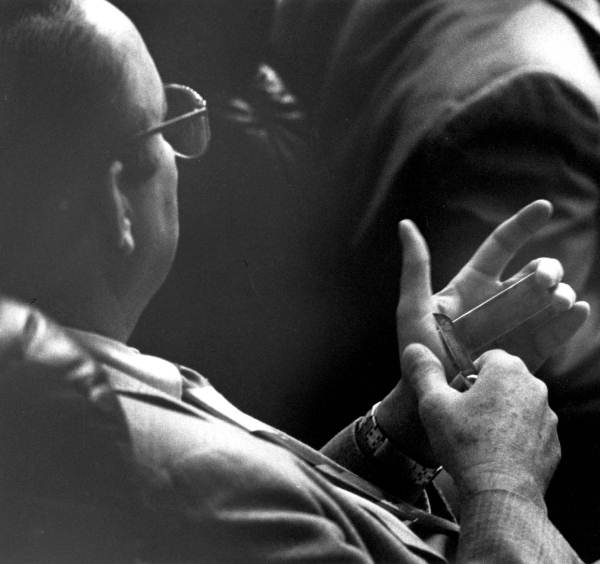 Representative Irlo "Bud" Bronson sharpening his knife during a debate.
