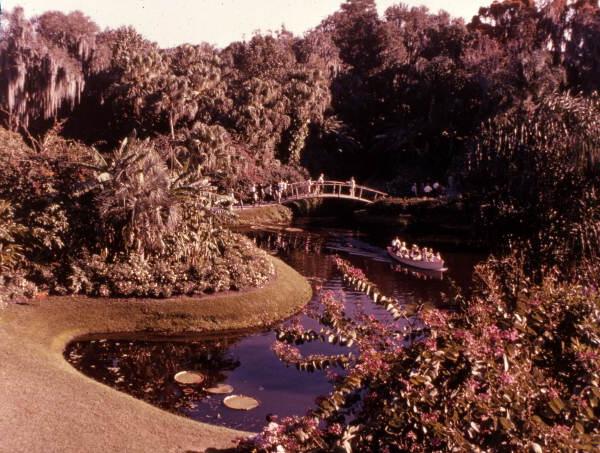View looking toward a rustic wooden footbridge over a waterway at the Florida Cypress Gardens theme park in Winter Haven, Florida.
