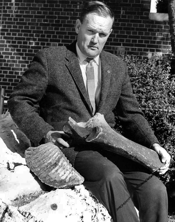 Man holding tooth and leg fossil of a Mammoth