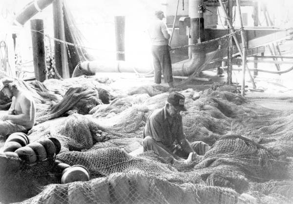 Workers repairing fishing nets