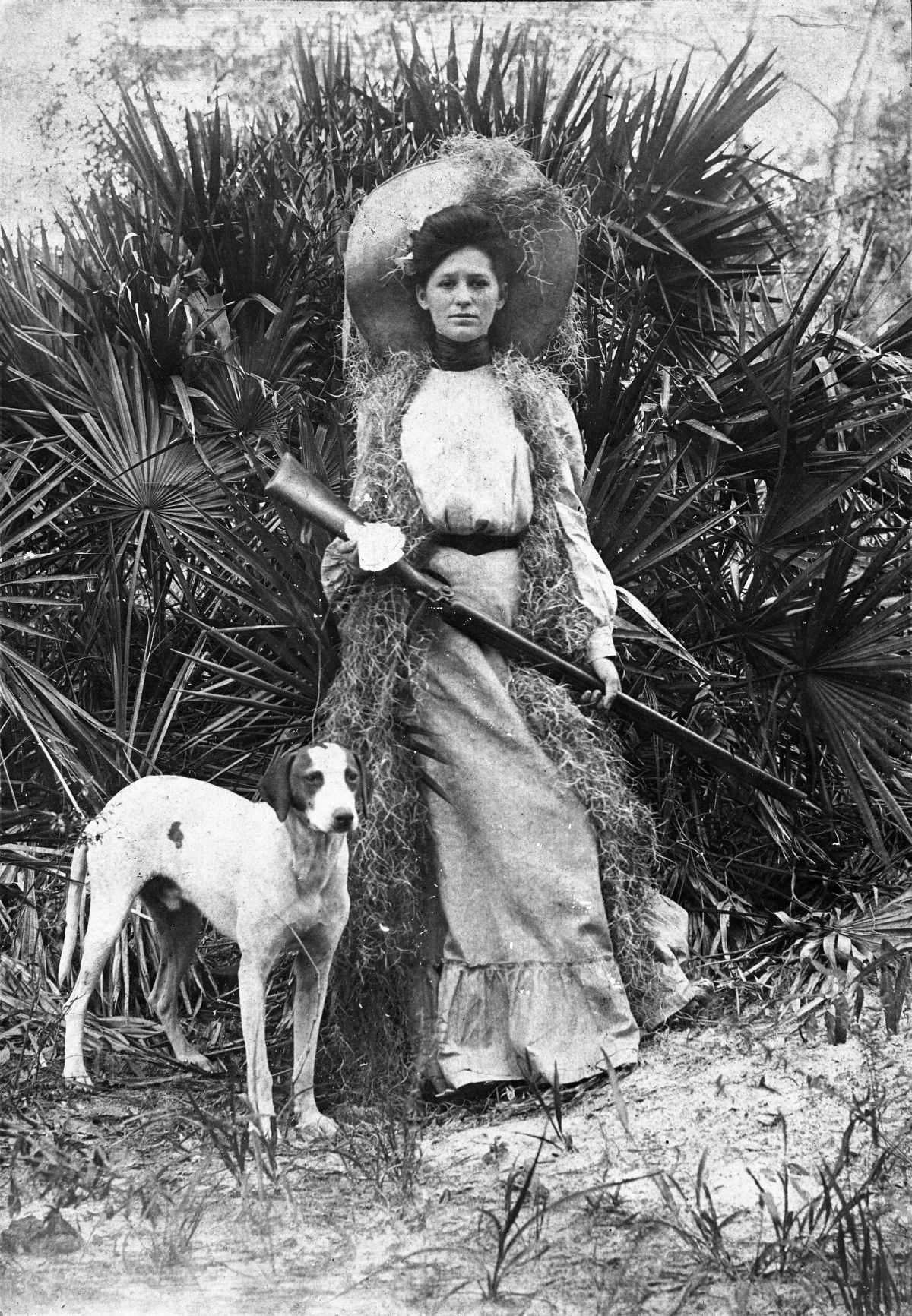 Woman with shotgun and dog