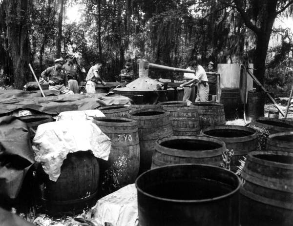 Sheriffs destroying distillery equipment.