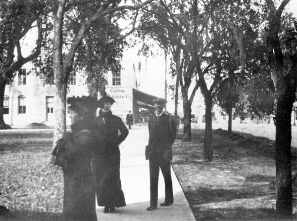 People standing on the sidewalk in front of the Capitol - Tallahassee, Florida.