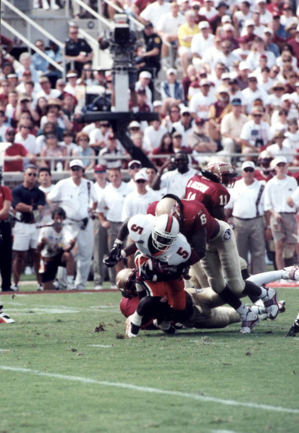 Miami running back Edgerrin James being tackled by an FSU defender at Doak Campbell Stadium - Tallahassee, Florida.