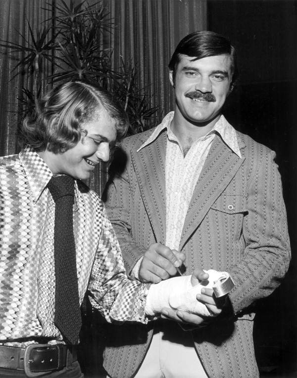 Miami Dolphins football player Larry Csonka signing autograph on cast of unidentified fan - Fort Lauderdale, Florida