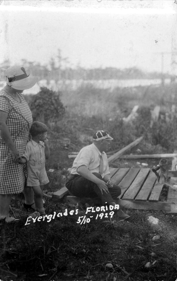 Postcard of the Miller family in the Everglades swamp watching a monkey drink from a bottle