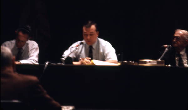 View of an unidentified man speaking during a meeting