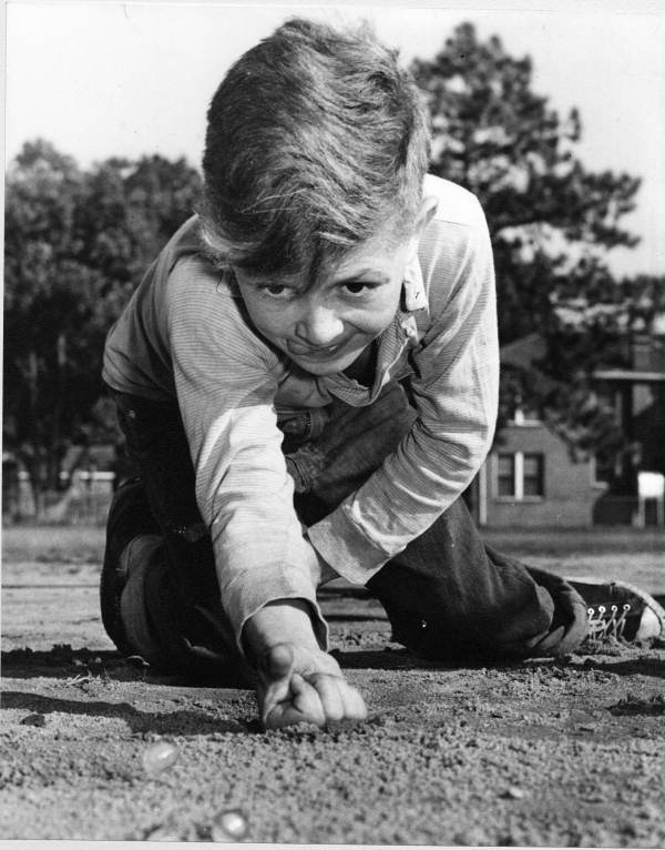 Concentration, a young boy playing marbles - Jacksonville, Florida .