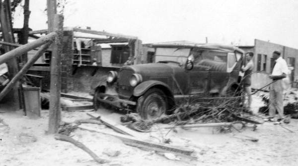 View showing damaged car and debris left by the 1928 hurricane - Palm Beach, Florida.