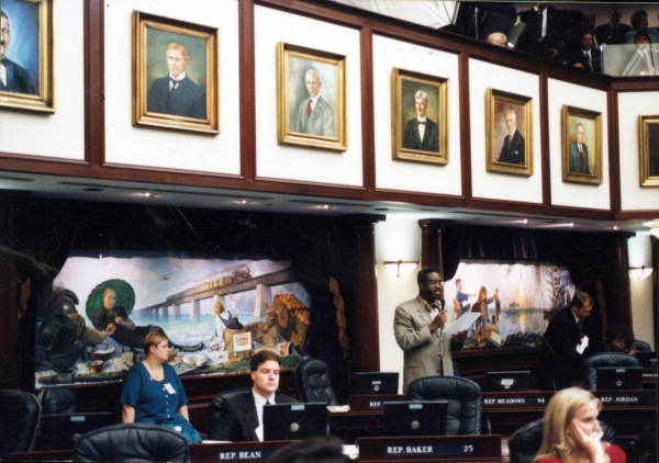 Interior view of the Florida House chamber showing Phillip J. Brutus speaking during a session in Tallahassee, Florida.