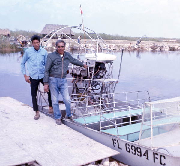 Seminole Indian men with an airboat in the Everglades.